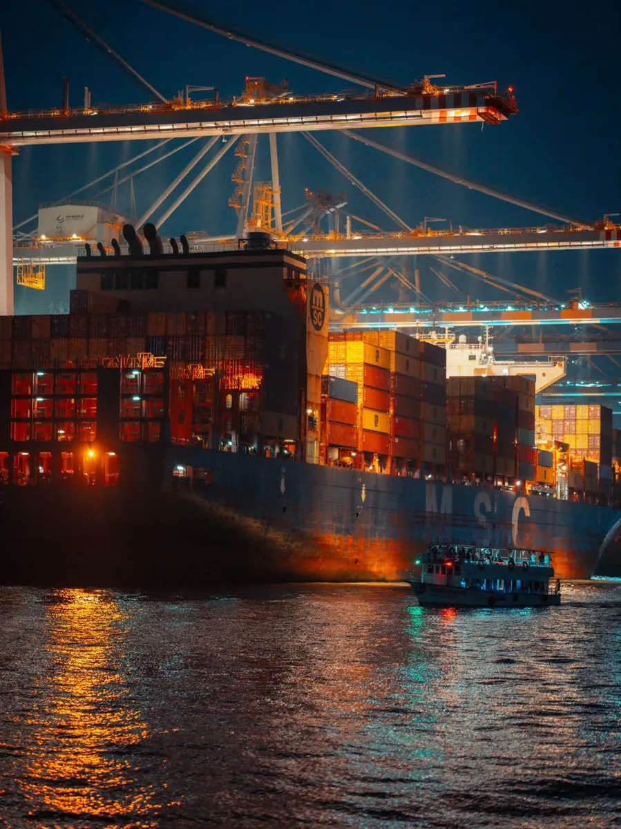 Buque portacontenedores en carga nocturna bajo las grúas del puerto